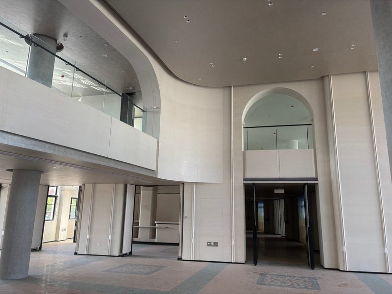 Two storey atrium clad in cast stone with arches and glass balustrade