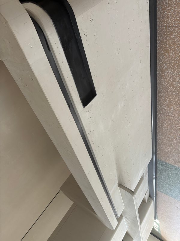 Cast stone cornice with a recessed shadow gap and stepped corner