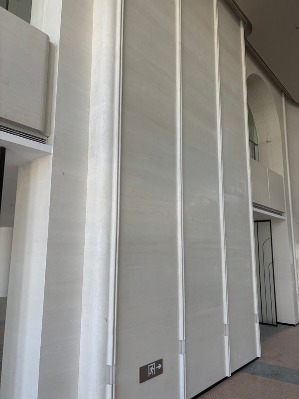 Full-height fluted cast stone wall with vertical ribs