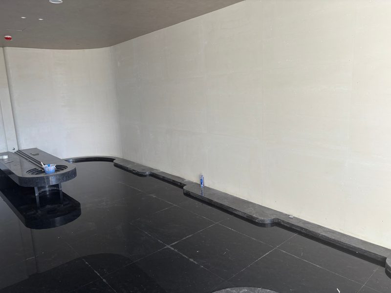 Cast stone walls in a spa wet area with black stone floor and ceiling